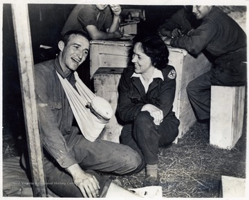 Cornelia Ladwig, Red Cross recreational director of Clarksburg, W. Va. keeps Pfc. Burton Crawford, left, of Elkins, W. Va. amused. He is one of the many recuperating patients in an evacuation hospital, somewhere in France.