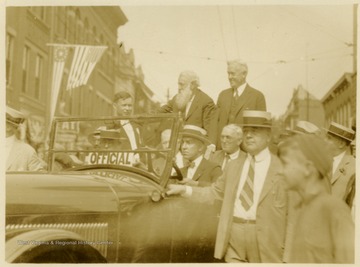 Davis Riding through the streets of Clarksburg, W. Va. John C. Johnson also in car.
