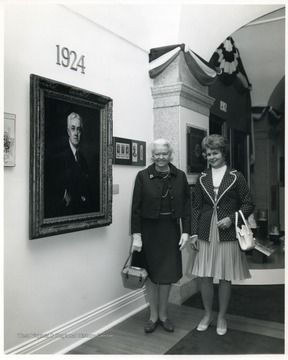 Julia Davis next to portrait of her father.