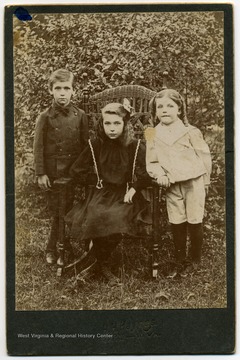 A boy and two girls outside.