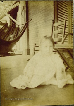 Margaret Holliday Gibson sitting on the floor of a front porch