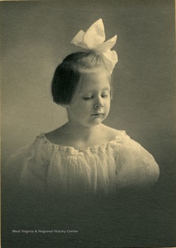 Young girl, Margaret H. Gibson, dressed in early 1900 style with huge hair ribbon
