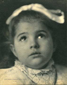 Young girl, possibly Frances Davenport Packette, gazing up, wearing a hair ribbon and lace collar.