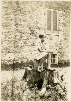 Young girl, Catherine, sitting on a tree stump with head in hand