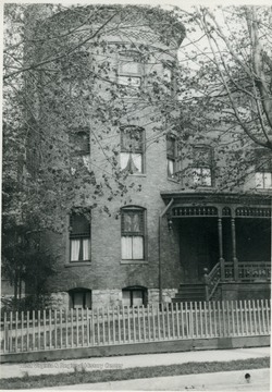 The photograph features the turret in front of the house.