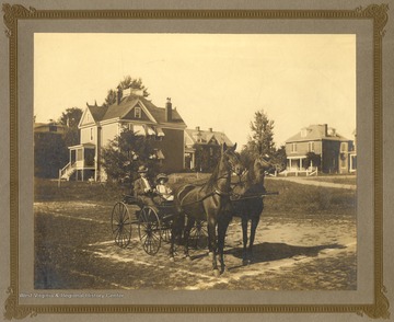 Father, William B. Packette and daughter, Frances Packette riding in a buggy drawn by two horses, Bird and Dan.
