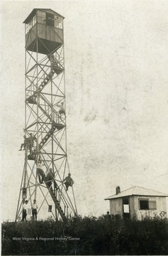 Unidentified people sitting on varies levels of a fire tower in the Monongahela National Forest 