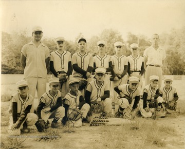 Team portrait of little league baseball team, coached by George DeAntonis, (standing, left).