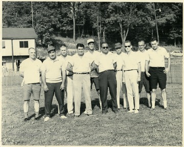 Group portrait of coaches at Bennett Field, Westover Park, in Westover, W. Va.  Left to right: Francis Wolfe, Vince Gargarella, B. G. Bennett, Joseph DeProspero, unidentified, Adam Pompili, unidentified, unidentified, Joe Bisilla, and Dick Pill. Wolfe and DeProspero served as presidents of the Wesmon Athletic Association in the 1960s.  Bennett Field is named after B. G. Bennett.