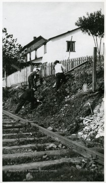 Unidentified men building a new fence around South Sabraton dwellings on Sturgiss Street.