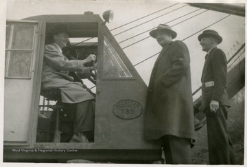 Left to right: City Manager Elmer Prince, Councilmen Barnard and Roby. Elmer Prince is seated at the controls.
