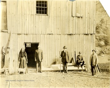 Group portrait outside a barn includes members of the Price family: Left to right, Unidentified woman and man, John Price, Oliver Price and Albert Price