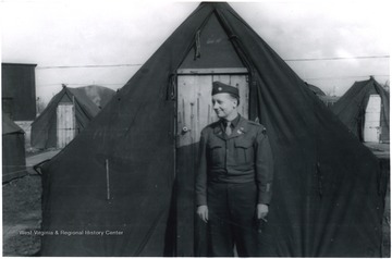 United States Army Major Elmer Prince stands outside his two man tent in Camp Philip Morris. This "cigarette camp" could hold up to 35,000 men. In 1946, men in all camps were waiting for their number to be called to board a "Victory Ship" home. The port at Le Havre became known as the "Gateway to America".