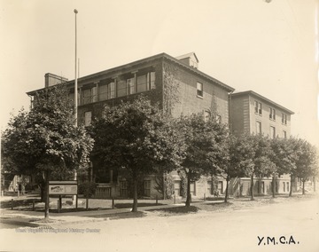 Young Men's Christian Association building with a "Rooms for Rent" sign outside on the street corner.