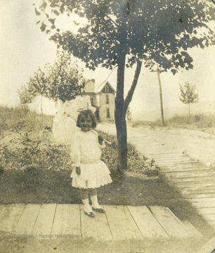 Little Margaret Mathers, daughter of Max and Anna Mathers, posing on the boardwalk at her home.