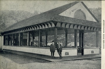 Two unidentified men stand outside the empty restaurant. 