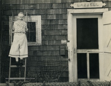 Blanche Lazzell from Maidsville, West Virginia, strings netting on the outside wall of her studio on Cape Cod.