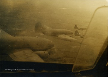 This photograph was taken from another aircraft flying in the same formation, note the open window/vent on the right.