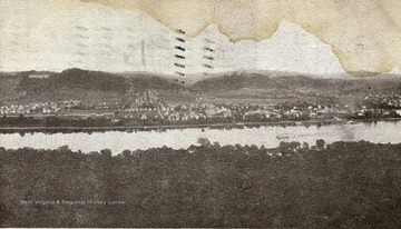 Postcard photograph of an elevated view of New Martinsville, West Virginia from over the Ohio River, in the Ohio hills.