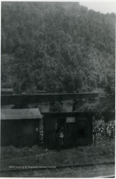The post office was located along a railroad track. The bridge in the background of the photograph crosses the New River near the mouth of Glade Creek.