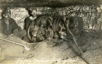 Coal miners, inside the mine using the Jeffrey machine to cut coal.