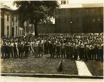 Inmates gathered in the yard, enclosed by buildings and a five foot thick wall at the state prison. Note some of the prisoners are wearing neckties. 