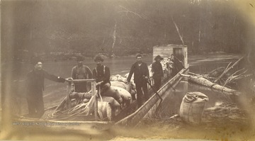 A barge loaded with supplies for the engineers and crews working on the Ohio Extension along the Tug Fork and Big Sandy Rivers between Welch in McDowell County and Kenova in Wayne County. None of the men are identified in the photograph.