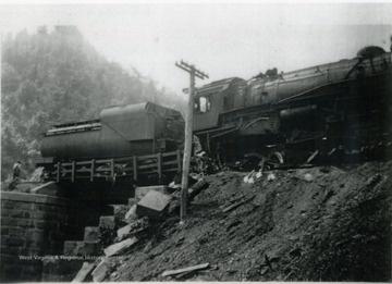A photograph of a train wreck on a bridge in southern West Virginia. The train is a coal feeder line and is property of Nicholas, Fayette &amp; Greenbrier Railroad. 