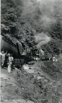 Unidentified railroad workers, among others survey the damage of a train wreck. The wreck occurred along a coal feeder line that ran from Rainelle to Swiss. 