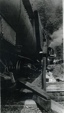 A train wreck which on a coal feeder line and property of Nicholas, Fayette &amp; Greenbrier Railroad. Unidentified railroad workers and others inspect the wreckage which occurred on a track that ran from Rainelle to Swiss. 