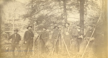 Anderson "Devil Anse" Hatfield, second from the left holds a surveying pole as several unidentified workers and civil engineers pose with their equipment during the construction of the Ohio extension of the Norfolk &amp; Western Railroad.