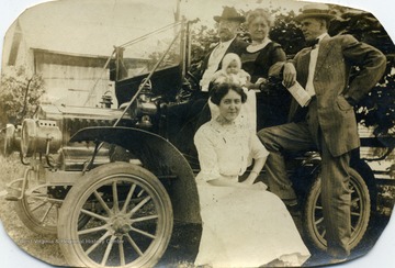 Information included with photograph: "Mr. &amp; Mrs. Waters of 1318 Quarrier St. Charleston, holding granddaughter, Jane Baily Ellison. Charles Alexander Ellison standing by his wife, Frances Waters Ellison on running board. Picture taken ca. 1912 ca. C. A. Ellison was [West Virginia] State Fire Marshall."