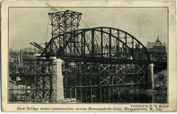 This is a postcard with a photograph on the front of a bridge under construction. The bridge was built across the Monogahela River in Morgantown, West Virginia. 