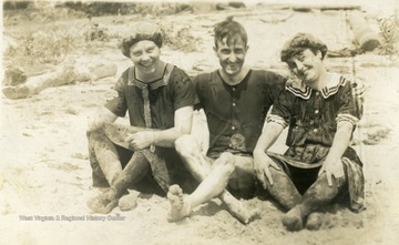 Swimmers drying on the beach, wearing fashionable bathing suits. L to R: Unidentified woman, Max Mathers and Anna Mathers of Morgantown.