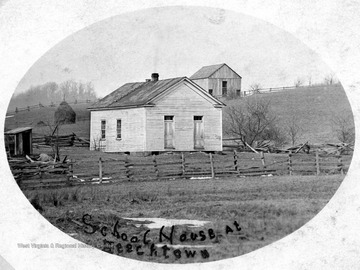 One room school house with an outhouse located to the left.