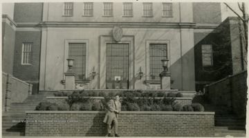 Unidentified male student poses outside the WVU Library (Wise Library). 