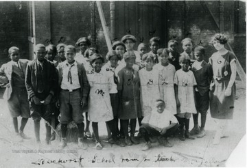 Class portrait of unidentified African-American students at Beechurst Elementary, a segregated school. Written on the photo is "Beechurst School room and teacher Mrs. Fallon(?)". Information on p. 113 in "Our Monongalia" by Connie Park Rice. Information with the photograph includes "Courtesy of Ivry Moore Williams."
