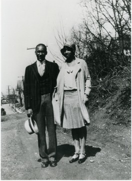 Charles and Martha Drew pose on a hill above a neighborhood. Information on p. 149 in "Our Monongalia" by Connie Park Rice. Information with the photograph includes "Courtesy of Bobbie Drew Ward."   