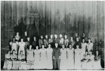 Monongalia High School Choir on stage. All persons in the photograph are unidentified. Information on p. 126 in "Our Monongalia" by Connie Park Rice. Information with the photograph includes "Courtesy of Peggy Cappell."   