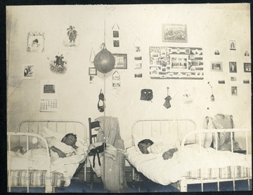 Students asleep in their dorm room. Note the punching bag hanging from the ceiling and several photos and memorabilia on the walls.