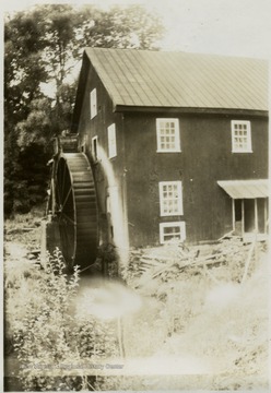 Large water-wheel is attached to the side of the mill.