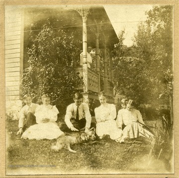 Sitting in the yard, left to right: Jim, Lucy, George Colebank, Ada, Danny, Dorrey Holden and "Ran". Standing on the porch, Ellie.