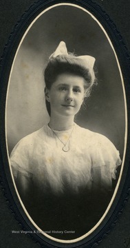 Unidentified young woman wearing white laced dress and locket.