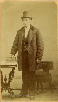 A dapperly dressed man in a suit and top hat. 