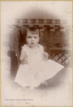 Unidentified baby girl wearing a white dress and a necklace. Large mounted prints such as this are called cabinet cards. 