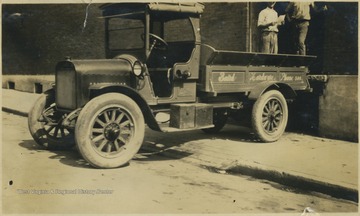 Written on the side of the truck with the name is "Phone 500". All persons in the photograph are unidentified. 