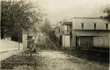 Postcard photograph of unpaved First Street in the town of Junior along the Tygart River.