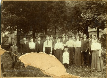 Several children of varies ages pose outside. The few names written on the back of the photograph include, "John A. Kuntz", "John King", "Buster Simms", and "James Mondry".