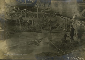 The man in the bowler hat who is standing is the chief of construction. All other persons in this photograph are unidentified.