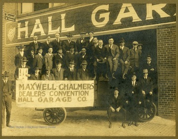 Group portrait of unidentified automobile dealers posed on a early model pick-up truck. Maxwell-Chalmers were the roots of the Chrysler Corporation.